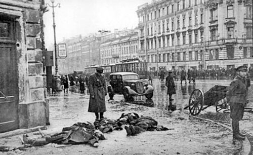 Фотография, сделанная во время блокады Ленинграда: русский мужчина смотрит вниз на мертвые тела на земле.